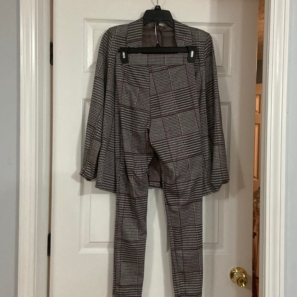 Pant suit. Blazer and pants. Houndstooth black, white , and red.